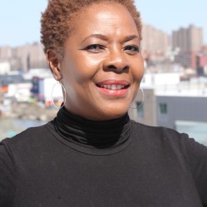 A headshot of Diane Carr-Joseph against a city skyline in the background.