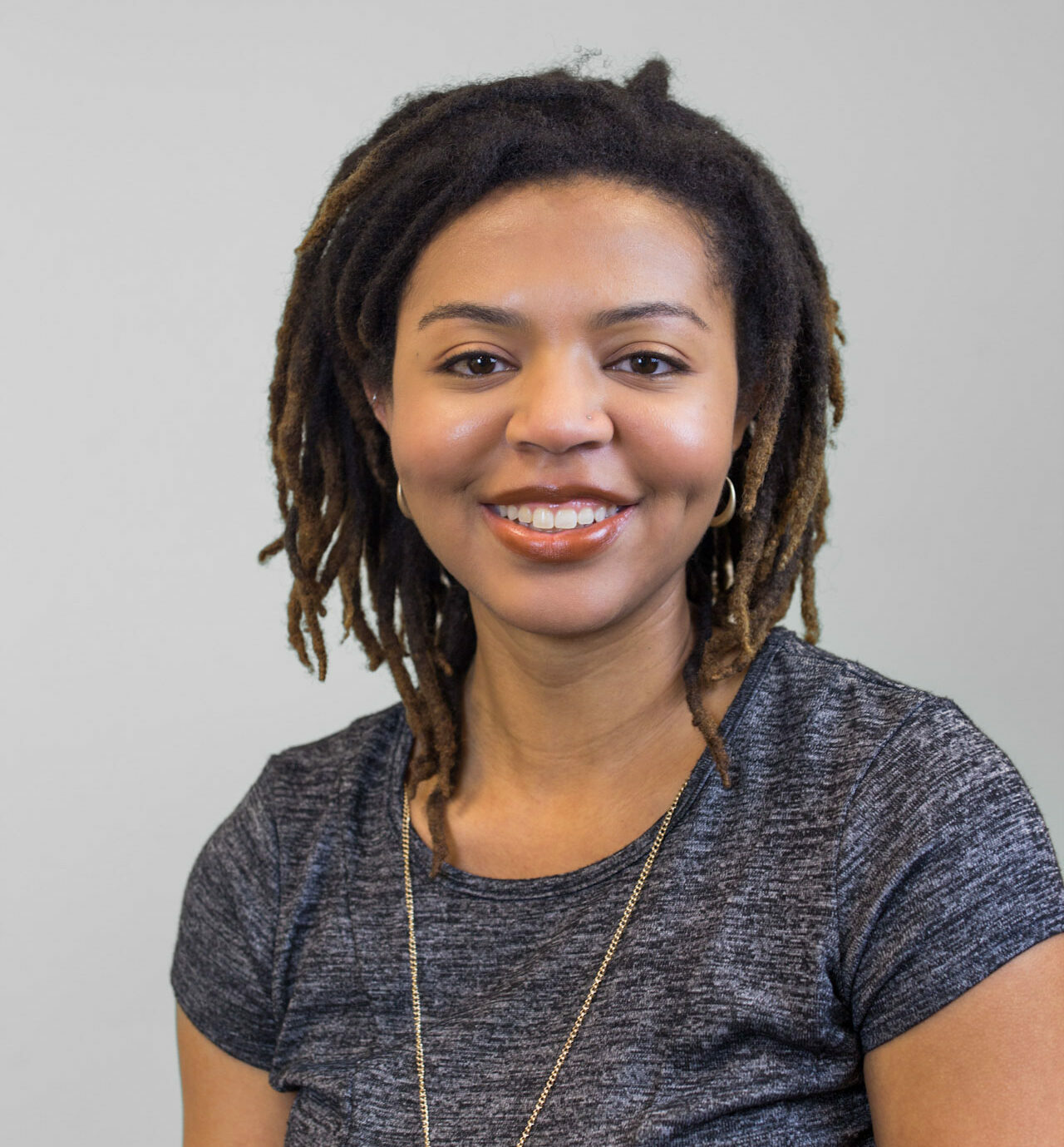 A headshot of Eboni Johnson-Kaba against a neutral grey background.